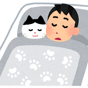 ネコと布団に寝る男性の画像